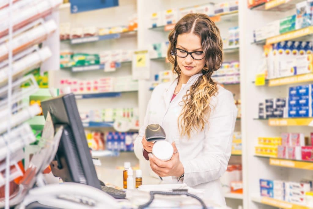 pharmacist scanning product at pharmacy cash register