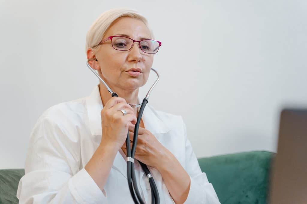 female doctor putting on stethoscope