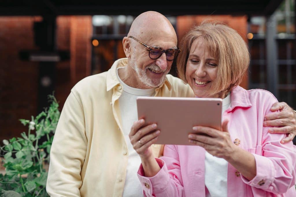 A senior couple reads something on a tablet